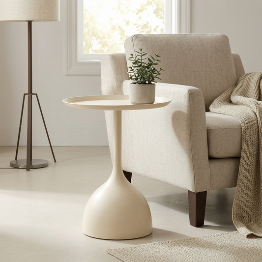 Mesa auxiliar pedestal de metal junto a un sillón