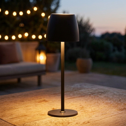 Lámpara de mesa inalámbrica encendida en una terraza al atardecer