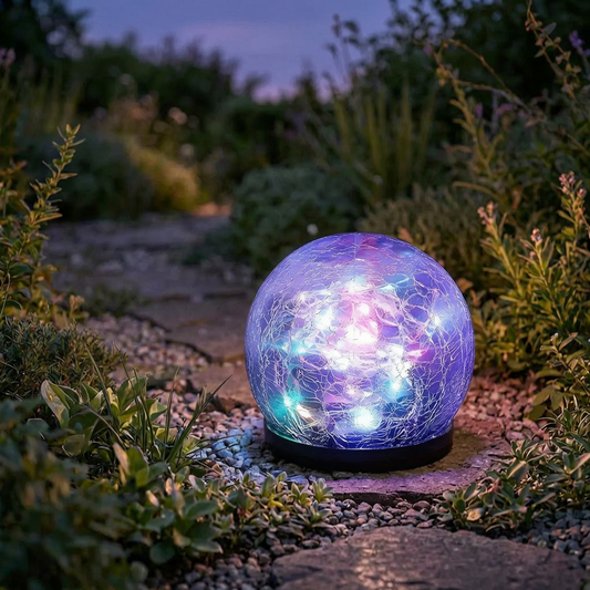 Luces solares de esfera de vidrio encendidas en un sendero de jardín