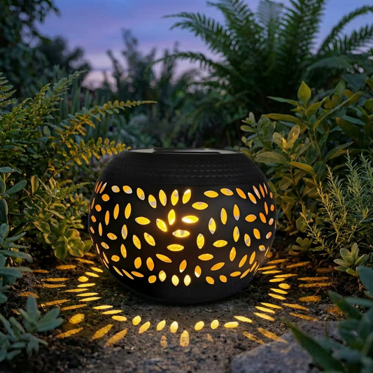 Farol solar de cerámica encendido en un jardín al atardecer