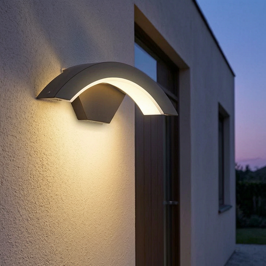 Lámpara de pared exterior encendida junto a la puerta de una casa