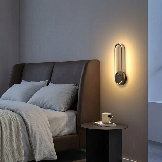 Lámpara de pared LED encendida junto a una cama