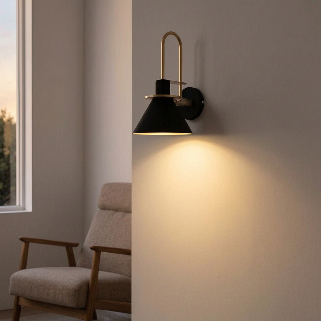 Lámpara de pared Mono encendida junto a un sillón de lectura
