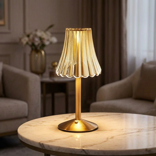 Lámpara de mesa de cristal encendida sobre una mesa de mármol