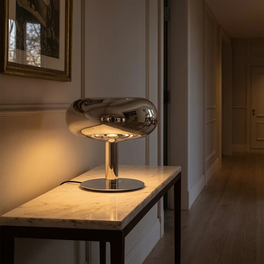 Lámpara de mesa con base de cristal encendida en un recibidor